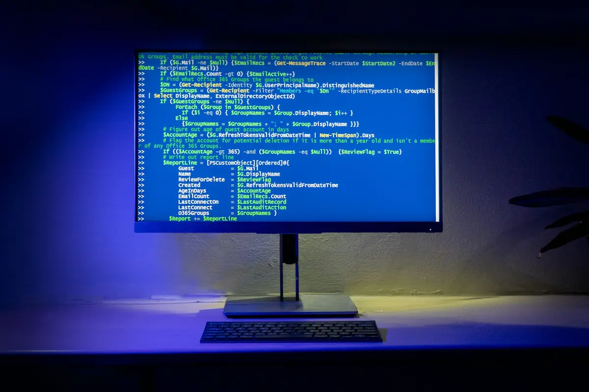 Monitor con codice sorgente in un ambiente di lavoro illuminato di blu